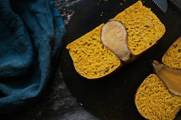 istock Yellow bread with a baked pear inside. Blue background  atmospheric still life 1201566487