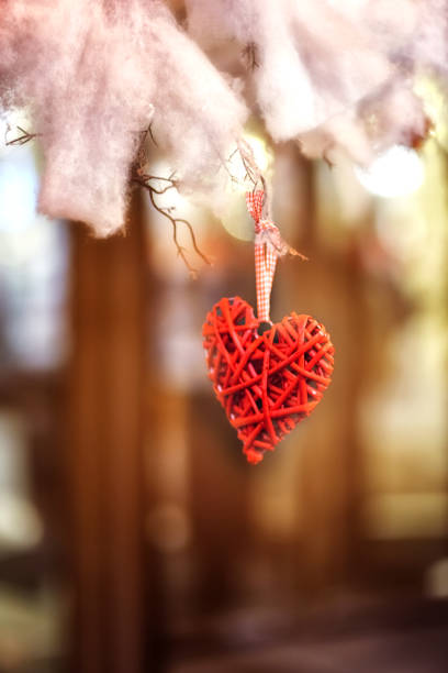 istock red heart hanging on a tree on a blurred background 1201568407