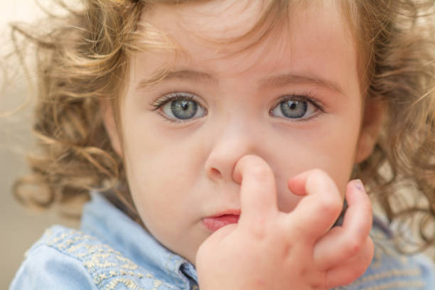 istock Young girl sad picking nose 1201569263