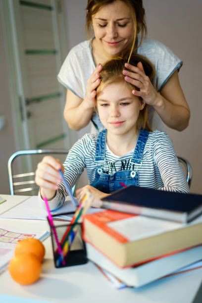 istock Happy Young Mother Helping Her Daughter While Studying At Home getting ready for school 1201569409