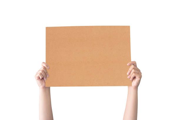 рука проведения белой пустой коричневой бумаге на белом фоне - cardboard sign стоковые фото и изображения