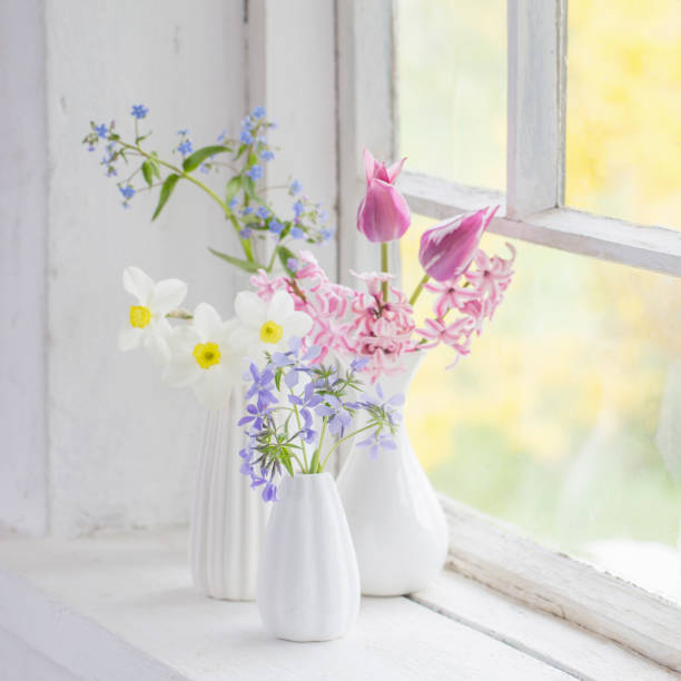 istock spring flowers in white vase on old windowsill 1201579093