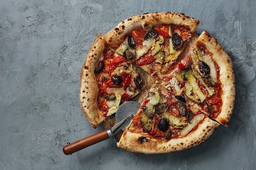 Homemade vegan Artichoke and Olive Pizza on concreted  background. Top view.