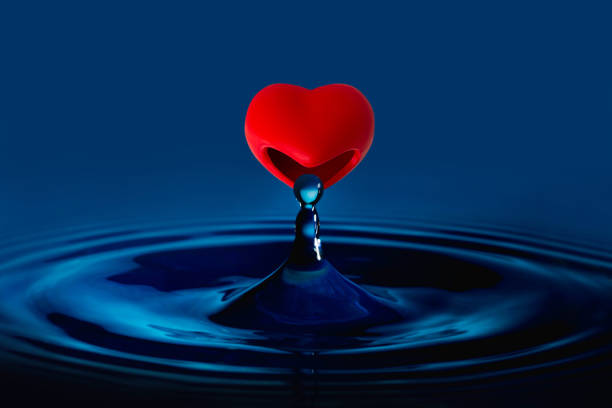istock The red heart is eating water drop splash in a glass cup blue colored. 1201594812