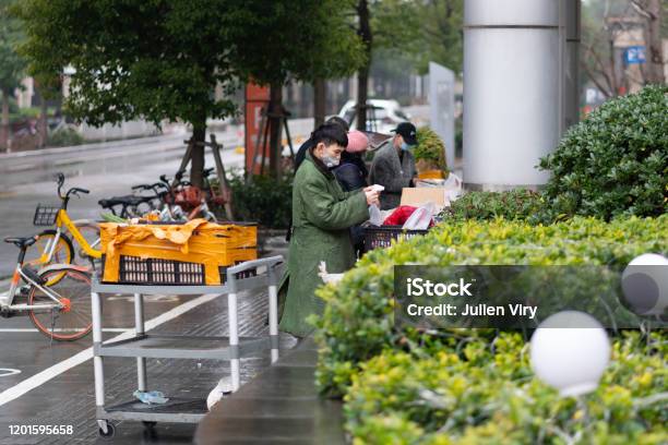 People Wearing Masks Selling Food In The Street During Second Day Of The Lockdown Of The City To Prevent Coronavirus Epidemic In Wuhan Hubei China Stock Photo - Download Image Now