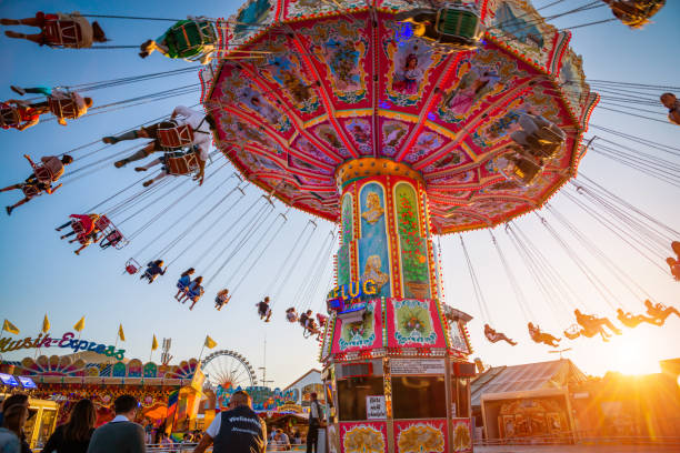 Munich, Germany - September 21, 2019: People enjoy the ride on a carousel during a sunny afternoon at the Oktoberfest in Munich (Germany). The Oktoberfest is the biggest beer festival of the world with over 6 million visitors each year.