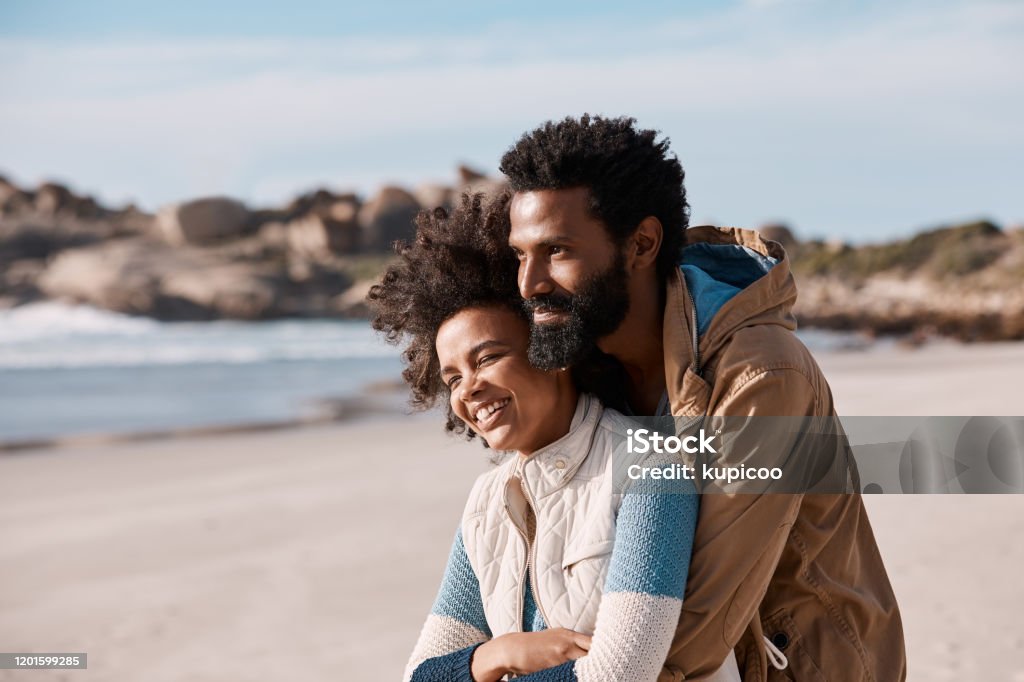 All you really need is lots of love Shot of a happy young couple spending a romantic day at the beach Adult Stock Photo