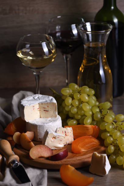 istock Cheese brie, camembert with white grapes, sliced persimmons and plums, a great appetizer for wine 1201603965