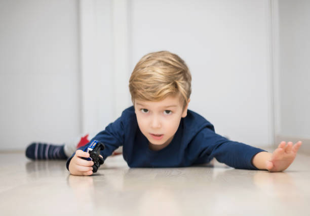 istock Small boy having fun with car toy on the floor. 1201609395