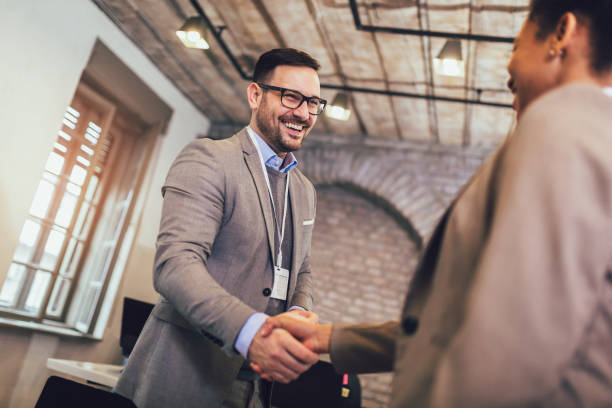 istock Young business people shaking hands in the office. 1201610601