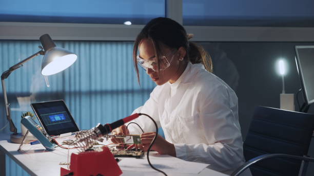 istock Side view of african american electronics specialist working with multimeter tester and other electronic devices in laboratory 1201612297