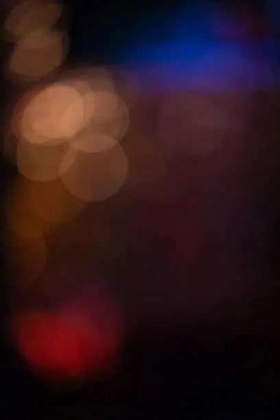 Intersection of circles of light with mixed shades of red and blue and degrees of transparency. Abstract bokeh.