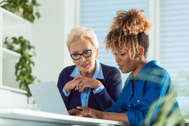 istock Female executives discussing over laptop at desk 1201613340