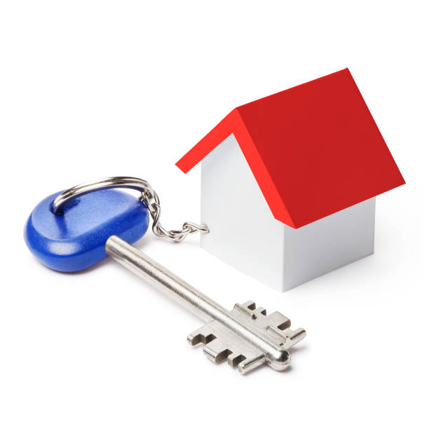 istock Blue big house key with a toy house on white 1201613420