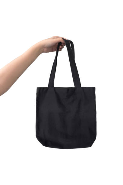 istock women hand holding canvas fabric black bag on white background 1201615113