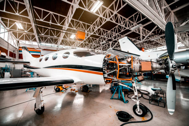 istock Partially disassembled small propeller airplane with opened motor compartment in a maintenance hangar 1201616923