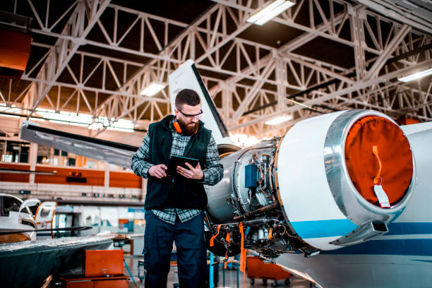 istock Aircraft engineer in a hangar holding a digital tablet while doing maintenance an airplane jet engine 1201619561