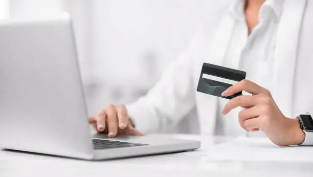 Photo of Cropped image of girl making donations using laptop