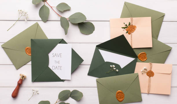 istock Stylish dark green envelopes with accessories on white 1201619970