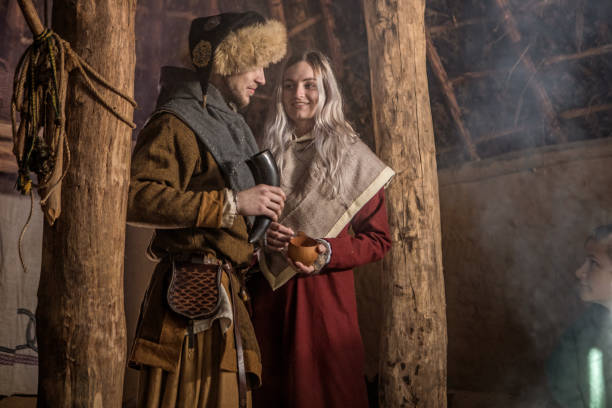 A viking couple posing for an pic in a viking settlement village hall setting