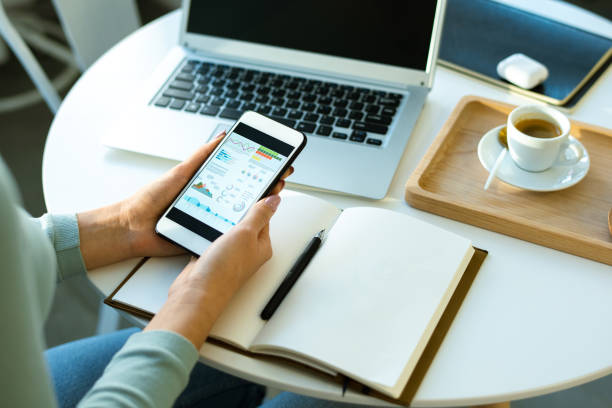 istock Hands of young economist with smartphone looking through financial data 1201622598