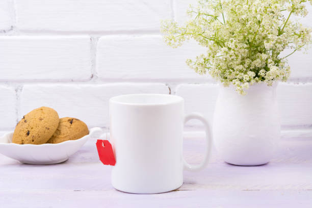 istock White coffee mug mockup with tender green flowers 1201624402