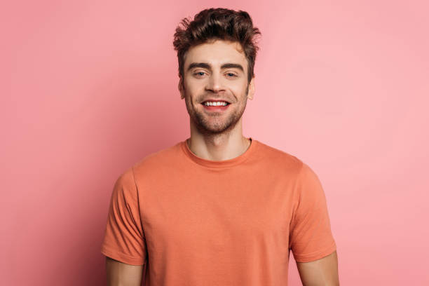 istock handsome, happy man smiling at camera on pink background 1201624910