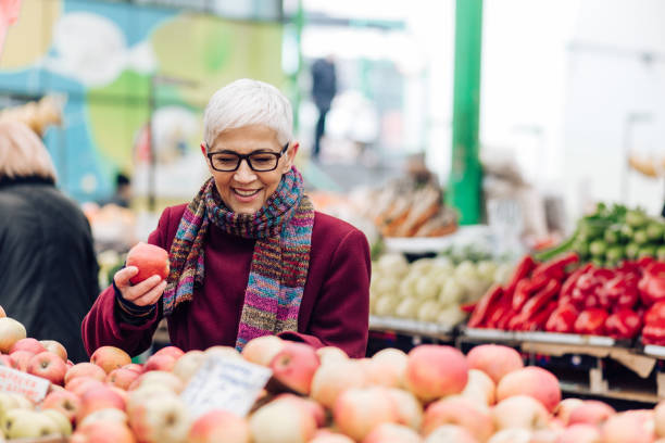 istock Senior woman buying apples 1201625622