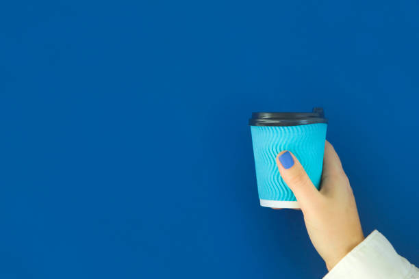 istock Blue paper cup for coffee in a female hand. 1201625897