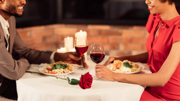 conjoints noirs ayant la date romantique mangeant dans le restaurant, panorama, cultivé - anniversary couple rose black photos et images de collection