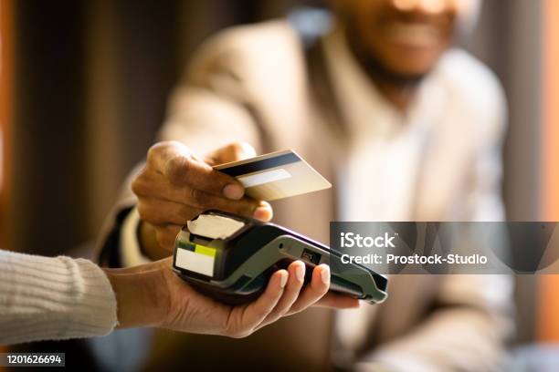 Afro Businessman Giving Credit Card To Barman Stock Photo - Download Image Now - Paying, Credit Card, Greeting Card