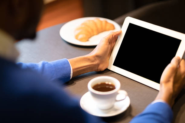 чернокожий мужчина с планшетом читает новости в кафе - e reader digital tablet cafe reading стоковые фото и изображения