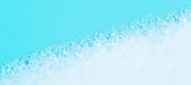 istock panoramic view of blue wet soap bubbles on blue background. Laundry detergent, suds textured pattern. White soap suds macro view. Abstract textured effect of blue soap foam close-up. divided frame 1201629731