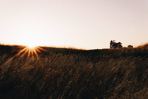 Classic Motorcycle on on a hill at sunset in a country field. Classic Motorcycle on on a hill at sunset in a country field. cafe racer stock pictures, royalty-free photos & images