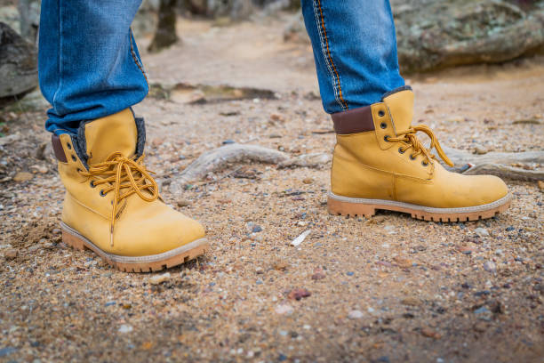 istock Pair of old yellow working boots on cliff 1201632391