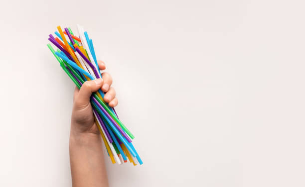 istock Hand holding heap of used plastic straws on white 1201632441