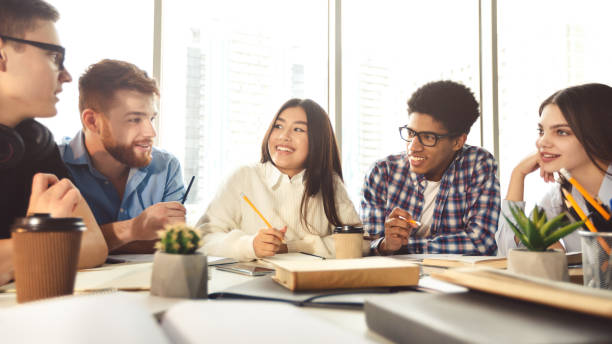 istock Happy groupmates preparing for final exams in library together 1201632972