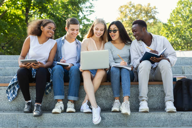 istock Group of international students using laptop at park 1201635211