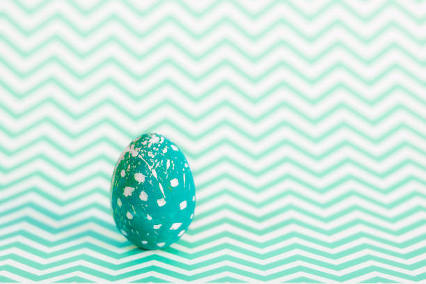 Easter egg on a geometric background, monochrome sea color.