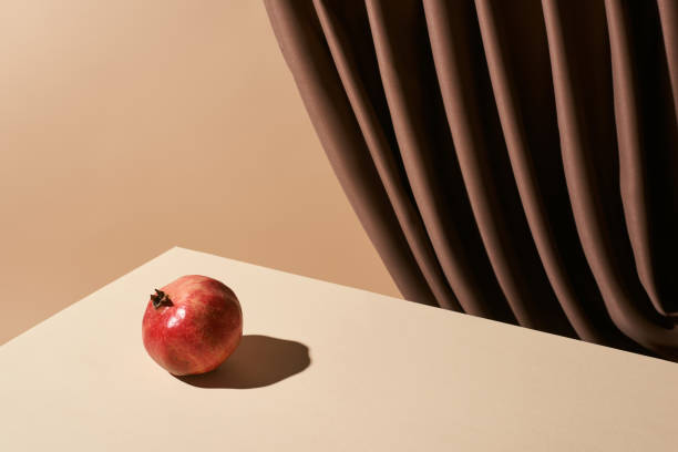 istock classic still life with pomegranate on table near curtain isolated on beige 1201642094