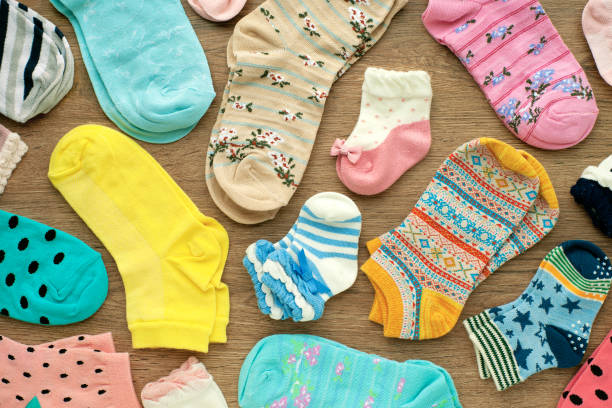 istock Socks of different sizes and colors on a wooden background. 1201643584