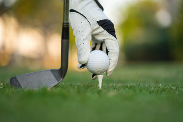istock Hand putting golf ball on tee in golf course. 1201646423