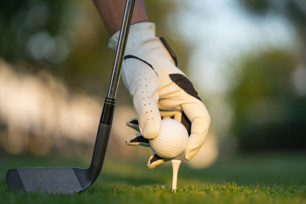 istock Hand putting golf ball on tee in golf course. 1201646430