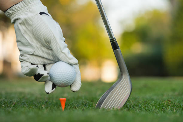 istock Hand putting golf ball on tee in golf course. 1201646441