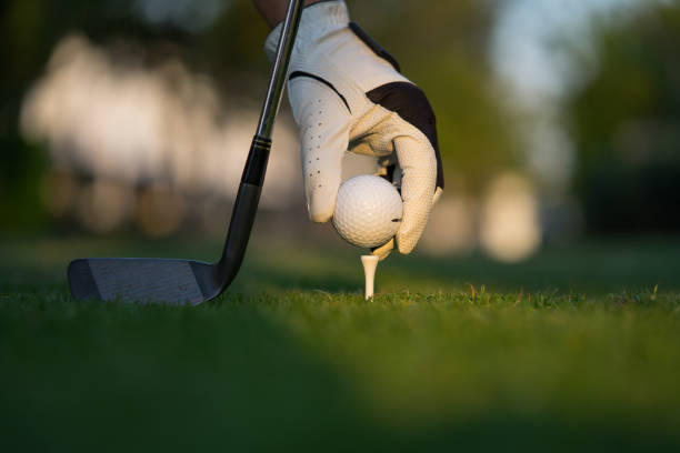 istock Hand putting golf ball on tee in golf course. 1201646445