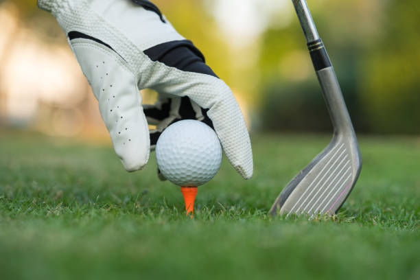 istock Hand putting golf ball on tee in golf course. 1201646472