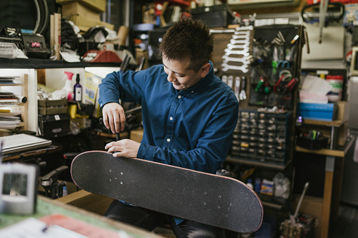Candid portrait of man repairing a skateboard.