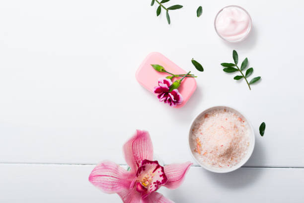 Orchid and bath salt, soap, cream cosmetic cream, soap and bath salt with pink flower, white wood table bath salt photos stock pictures, royalty-free photos & images
