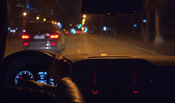 hands on the steering wheel of a car - car dashboard night driving imagens e fotografias de stock