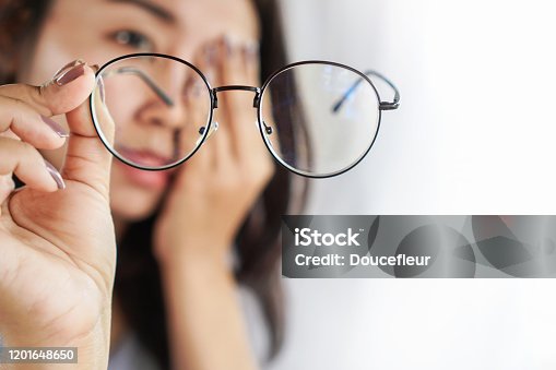 istock Asian woman hand holding eyeglasses having problem with eye pain, blur vision 1201648650